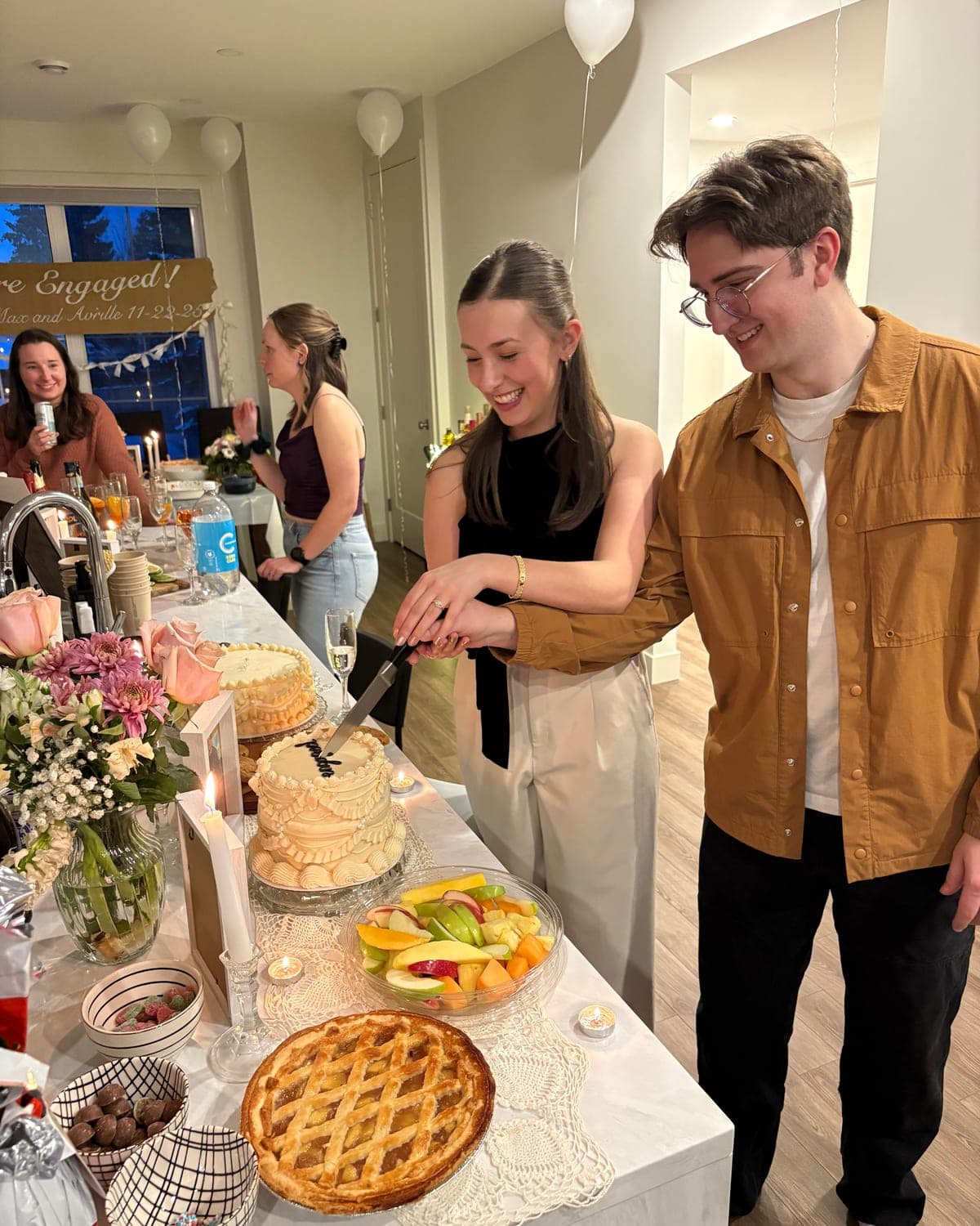 Avrille and Maxwell cutting a cake at their engagement party.